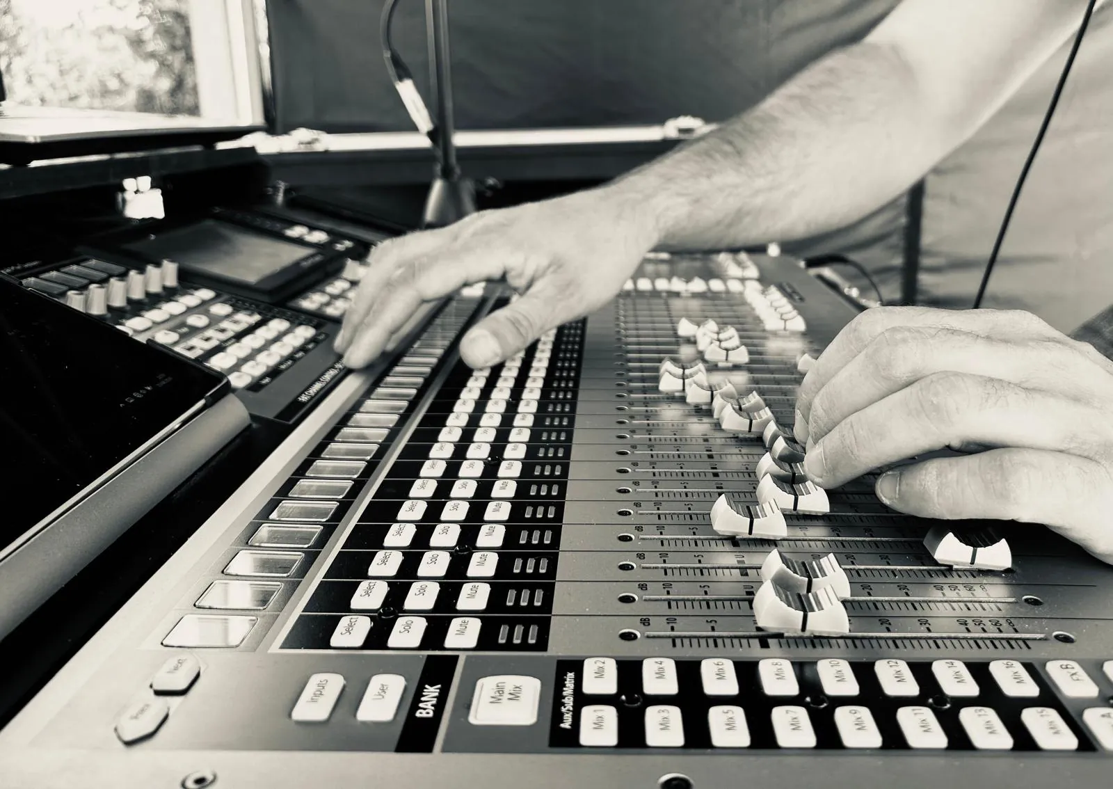Hands on the faders of the mixing desk